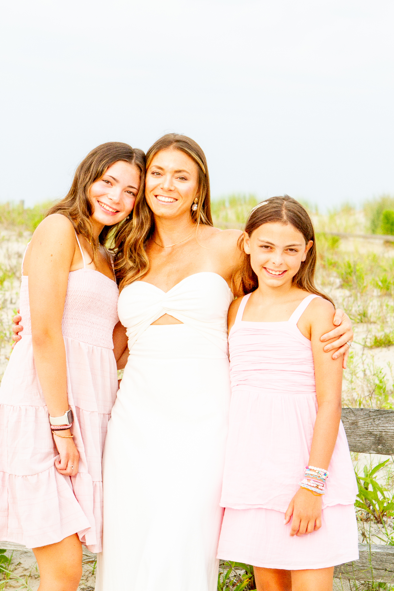 Mother with her two daughters in pastel dresses by the dunes at the Jersey Shore